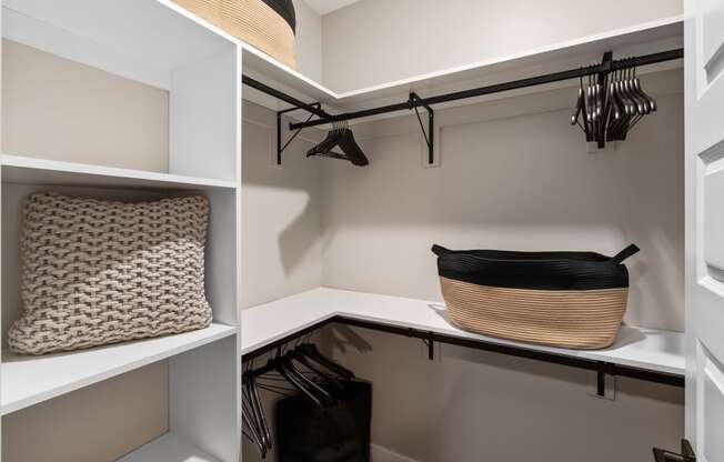 a walk in closet with shelves and a basket on a shelf