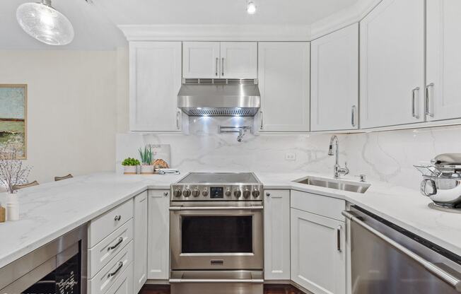 a white kitchen with stainless steel appliances and white cabinets