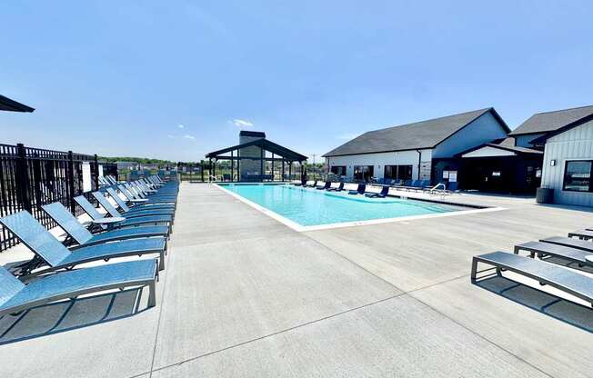 A pool area with sun loungers and a pavilion.