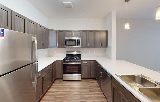 A modern kitchen with stainless steel appliances and a breakfast bar at Meadowbrooke Apartment Homes in Kentwood, MI 49512