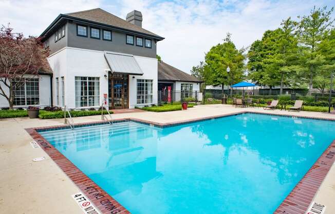 a swimming pool with a white building in the background at Lincoln at Wolfchase, Tennessee