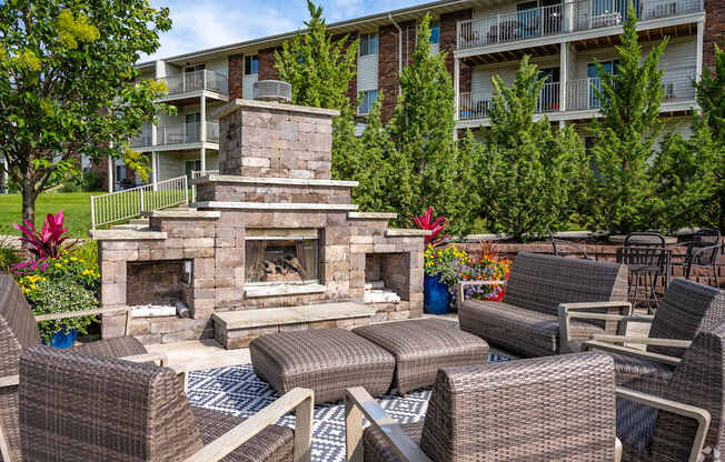 A patio with a fireplace and chairs.