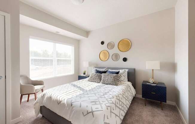 A bedroom with a bed, chair, and wall decor.