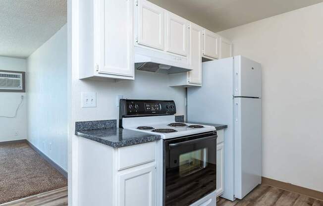 A kitchen with white cabinets and a black stove top oven.