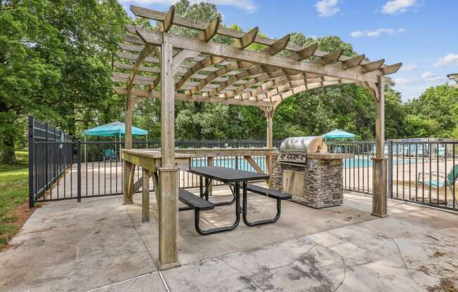 a picnic area with a grill and a pergola