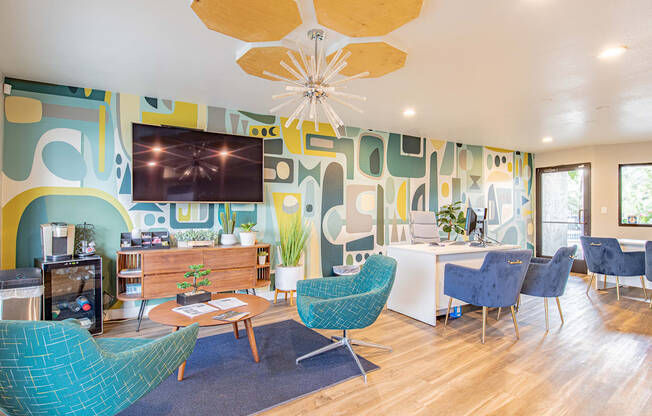 a living room with blue chairs and a table and a television