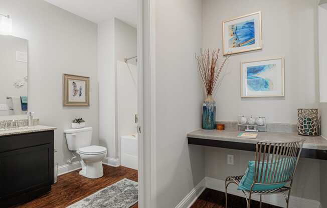 a bathroom with a toilet and a sink and a chair