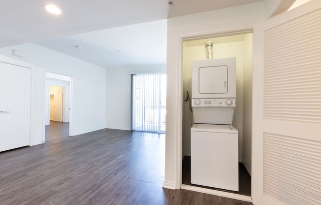 an empty living room with a white stove and a microwave in it