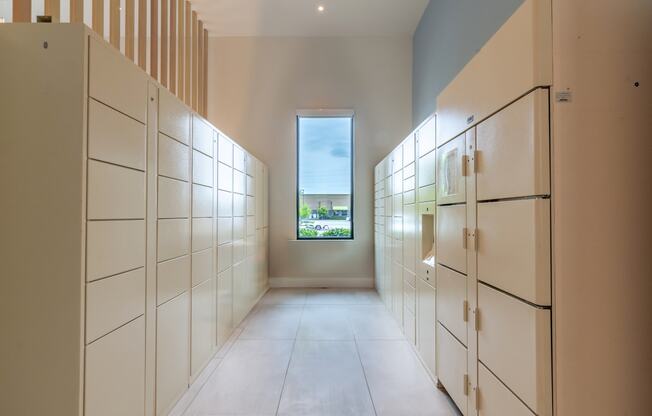 a long walkway with white cabinets and a window at the end  at Century West Pryor, Lee's Summit, MO