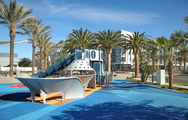 a slide at a water park at a resort with palm trees