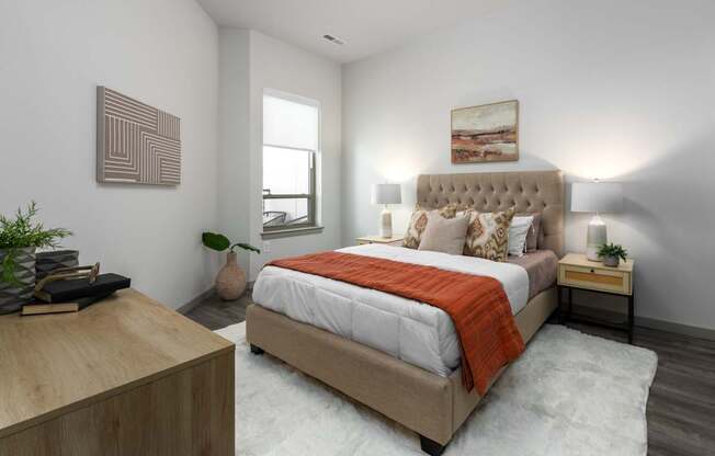 A bedroom with a large bed and a wooden nightstand.