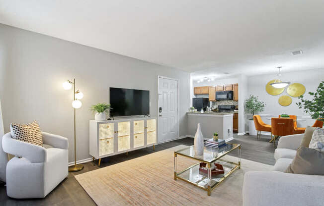A living room with a white sofa, a white armchair, a white cabinet, a white TV, a white rug, a white floor, a white ceiling, a white wall, a white door, a white table, a white