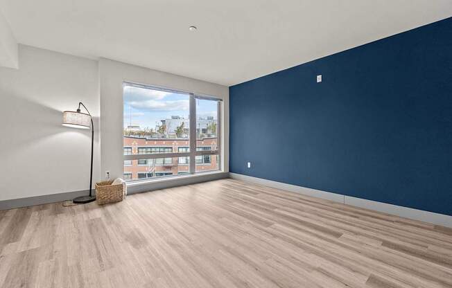 A room with a blue wall and a window overlooking a cityscape.