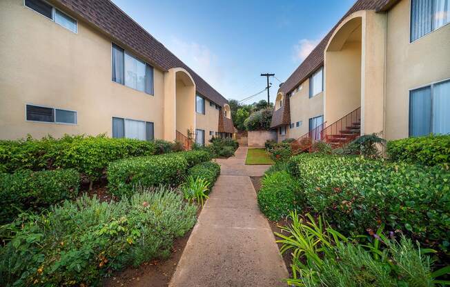 the walkway between the units is lined with plants and bushes