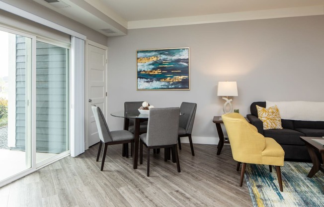 a dining area with a table and chairs and a sliding glass door leading to a patio