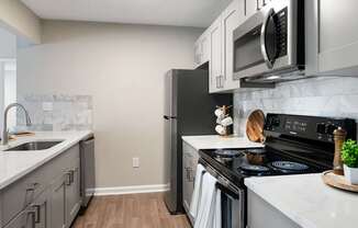 A kitchen with a black refrigerator, stove, and oven.