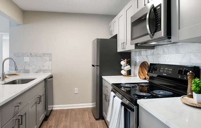 A kitchen with a black refrigerator, stove, and oven.