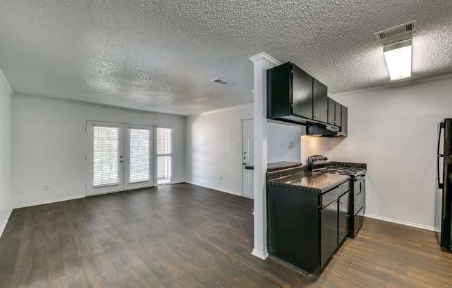 the living room and kitchen of an empty apartment with a stove and refrigerator