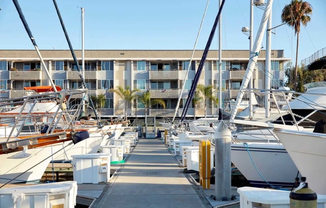 a row of boats parked in a marina in front of a building