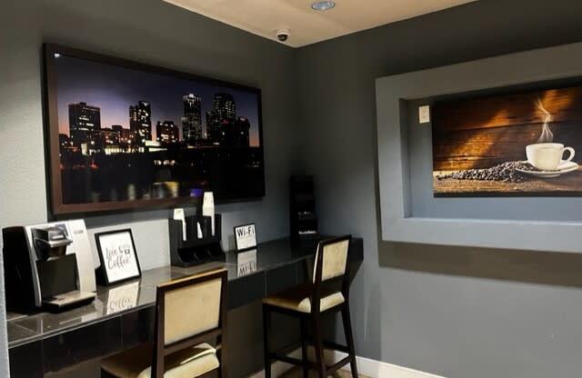 a room with a desk and chairs and a large picture of a city on the wall At Metropolitan Apartments in Little Rock, AR