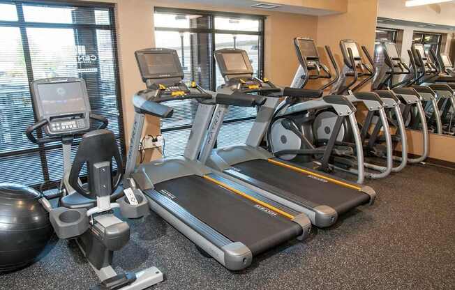 A gym with treadmills, elliptical machines, and other exercise equipment.