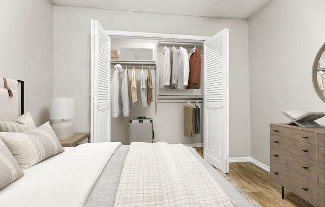 a bedroom with a bed and a closet full of clothes