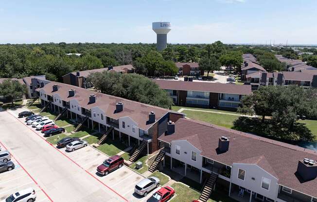 A parking lot with cars and a building with a tower in the background.