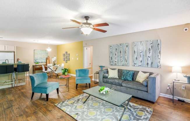 a living room with a couch and a ceiling fan at Avalon Apartment Homes in Starkville, MS 39759