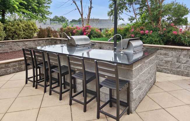 outdoor kitchen with stainless steel grills and bar seating