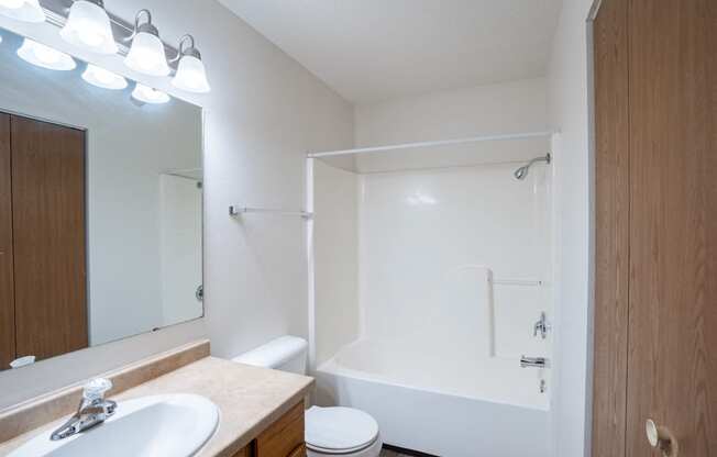 a bathroom with a shower and a sink and a mirror. Fargo, ND  Prairie Park Apartments