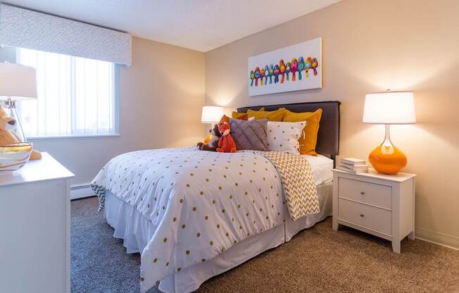 A bedroom with a bed, nightstand, and lamp.