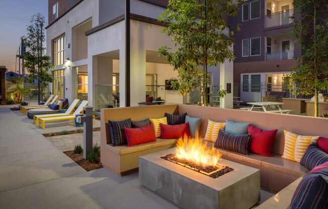 A modern outdoor seating area with a fire pit in the center.
