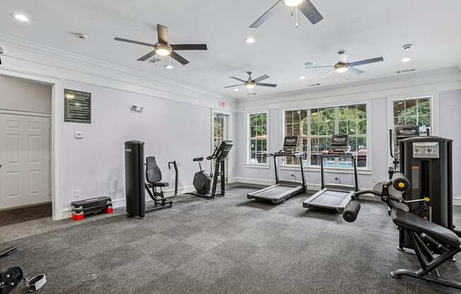 A spacious gym with a variety of equipment including treadmills, stationary bikes, and weight machines.