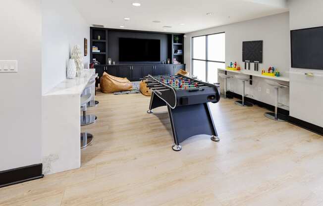 a game room with a foosball table and a tv