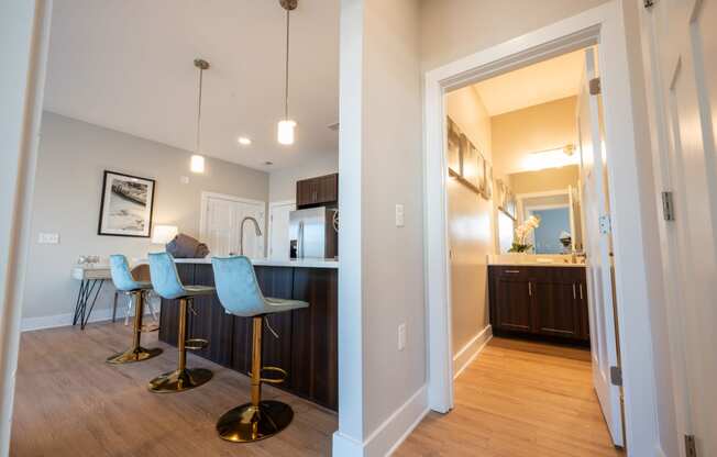 a living room and kitchen with a bar and stools