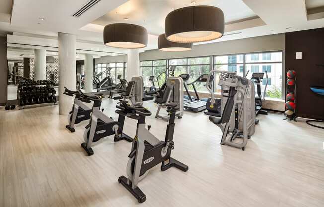 a gym with treadmills and other exercise equipment on a wooden floor