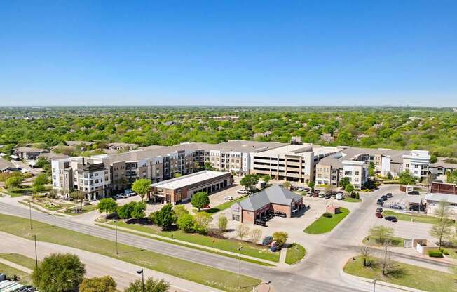 A view of a residential area with apartment buildings and a parking lot.