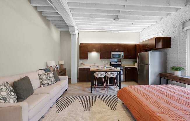 A modern living room with a white couch and a kitchen area in the background.
