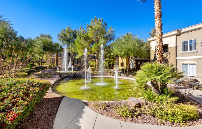 A beautiful garden with a fountain in the middle.