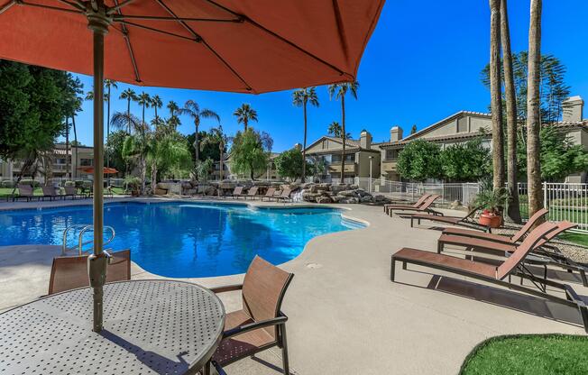 a group of lawn chairs sitting next to a pool of water