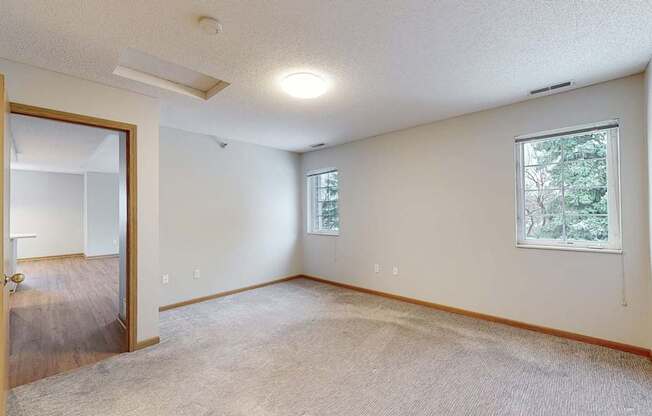 A room with a door, a window, and a carpeted floor.