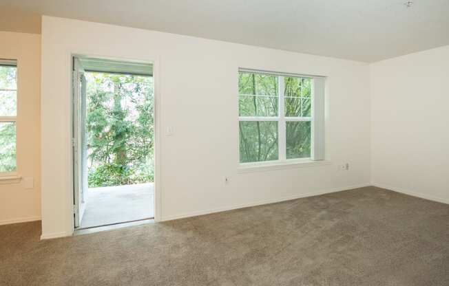 an empty bedroom with a door leading out to a yard