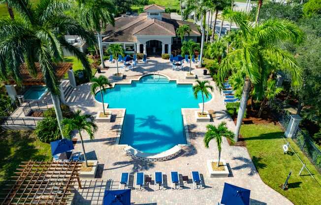 a large swimming pool with a house in the background at Heritage Bay, Jensen Beach, FL 34957