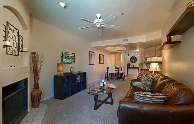Apartments for Rent in Old Town Scottsdale - Cibola - Living Area with Grey Carpeting, Ceiling Fan, and Fireplace
