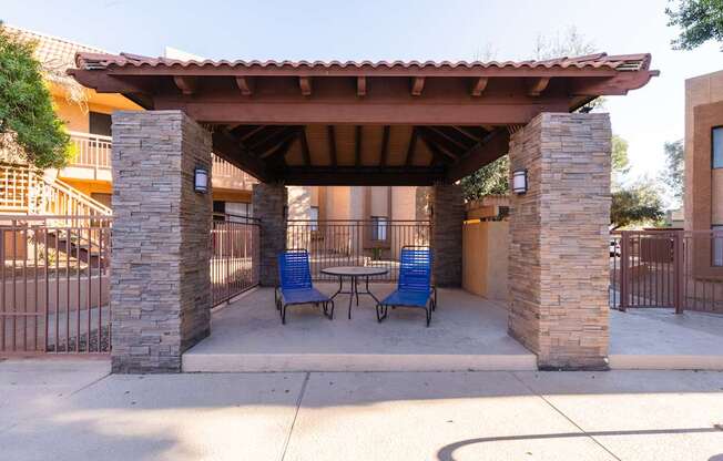 A patio with a table and chairs under a roof.
