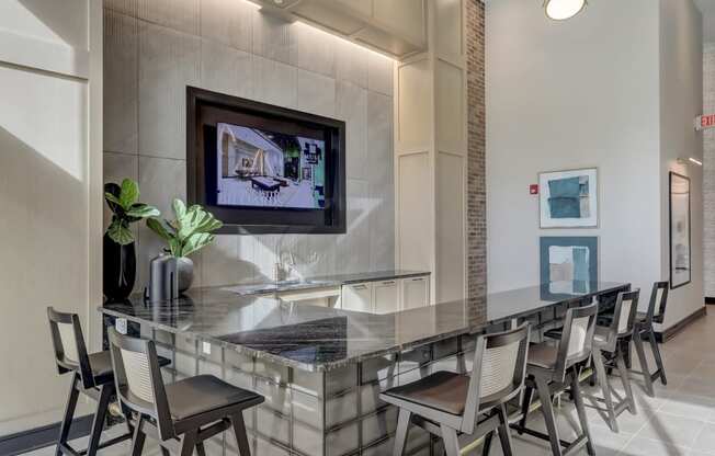 a long bar with chairs and a tv on the wall