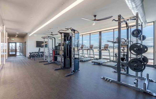 A spacious gym with a variety of equipment and a view of the outside.