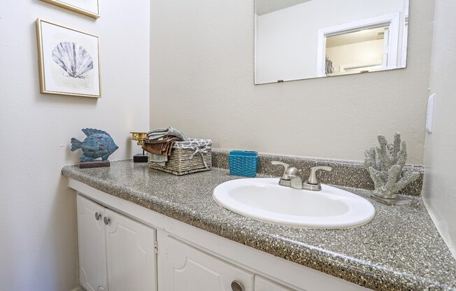 A bathroom with a white sink and a mirror above it at The Drake in Bossier City, LA