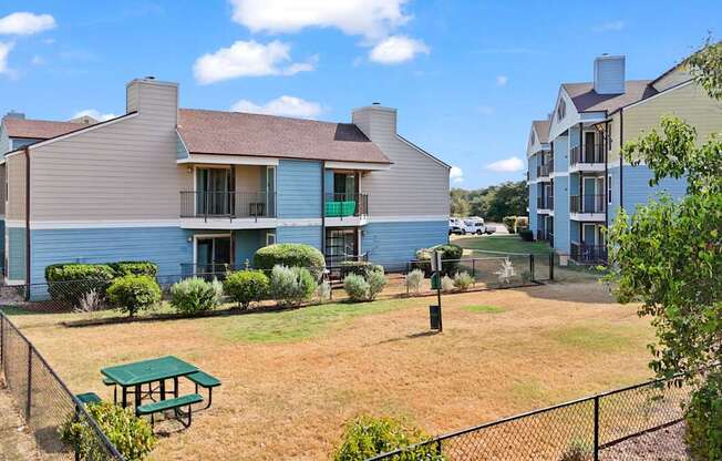 A blue house with a green picnic table in front.
