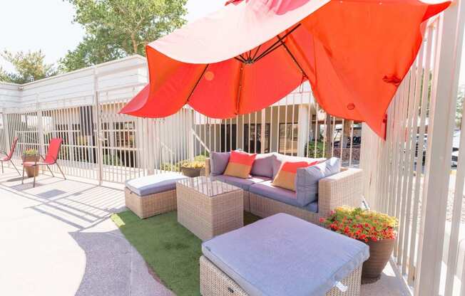 a patio with wicker furniture and an umbrella